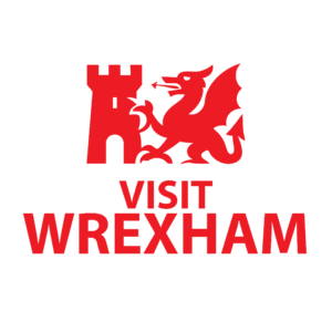 A red logo on a black background featuring a stylised castle tower beside a Welsh dragon. Below the graphic, the words “Visit Wrexham” are written in bold red text.